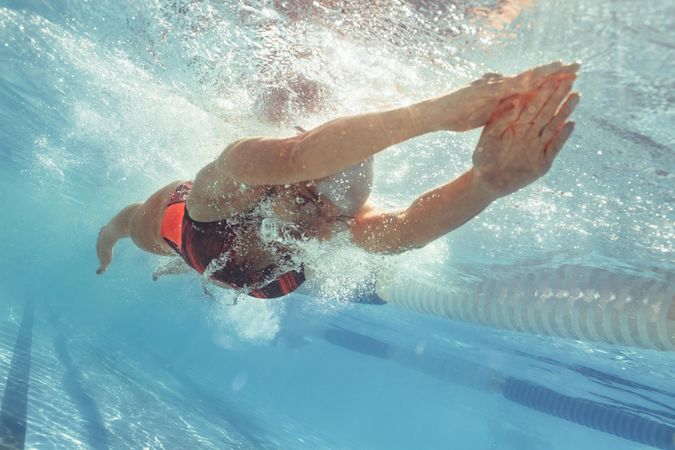 Underwater shot of female swimmer gliding in pool