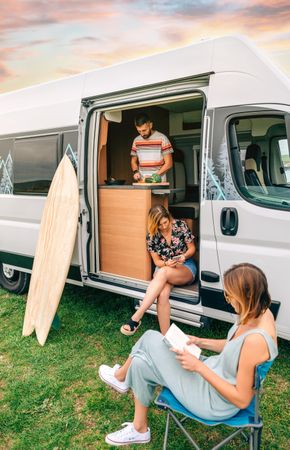 Group of friends traveling in a camper van, vertical