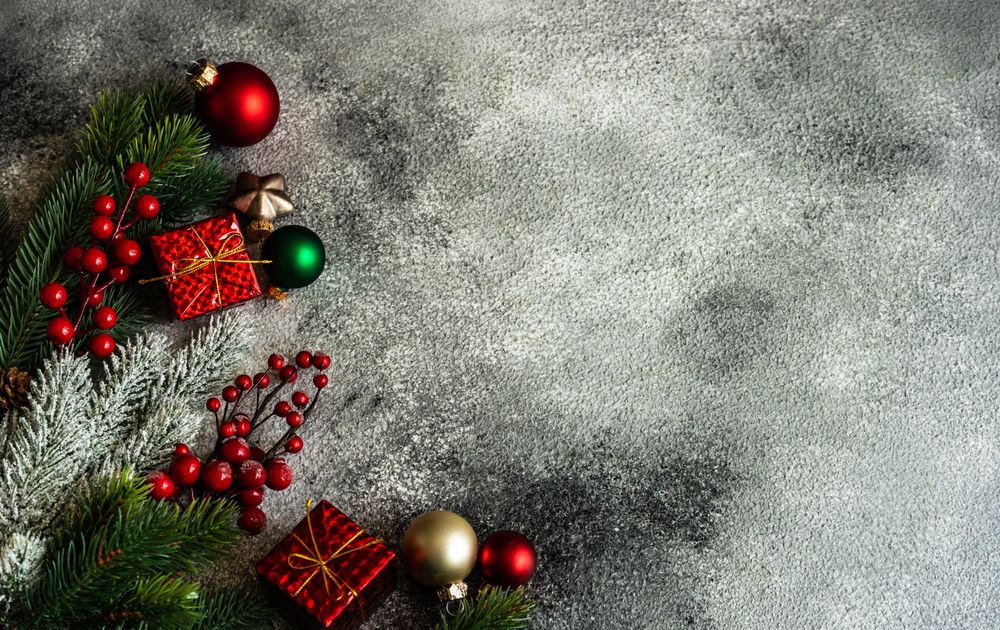 Christmas frame with branch and holly on stone background