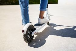 Back of woman standing on scooter