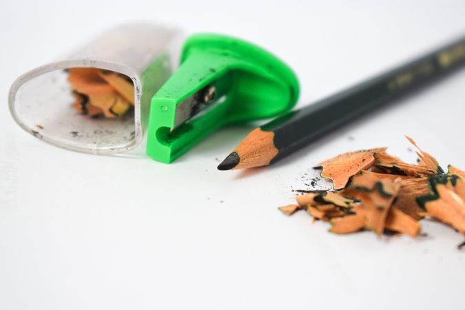 Sharpened pencil on table next to green sharpener with space for text