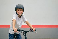 Smiling boy in helmet sitting on bicycle