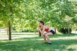 Woman squatting in park