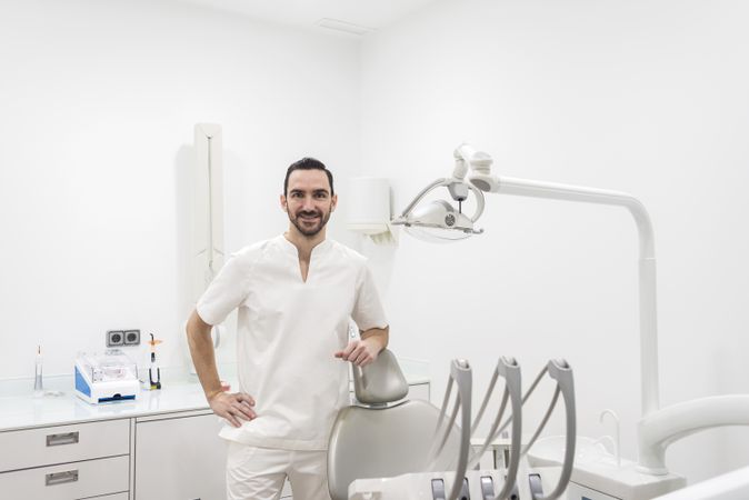 Portrait of a handsome dentist wearing a uniform at in office