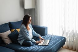 Pregnant woman working on laptop at home