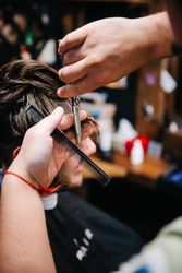 Barber cutting man's hair in close-up