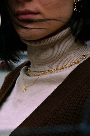Cropped image of woman with short hair wearing brown cardigan