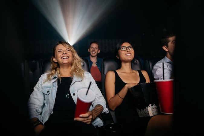 Young women and men watching movie in cinema