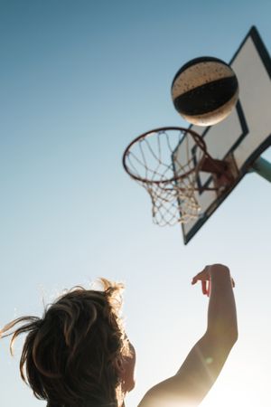 Kid throwing basketball into hoop