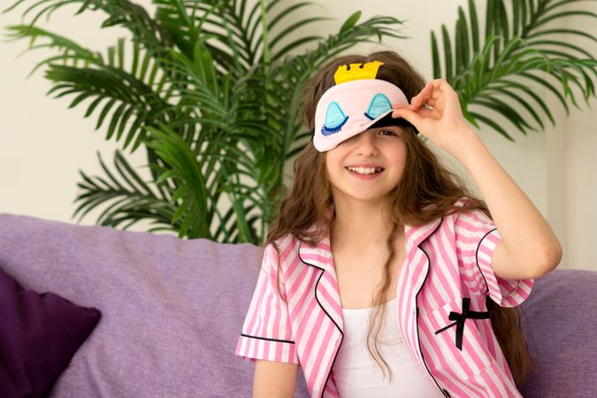 Young girl adjusting sleep mask