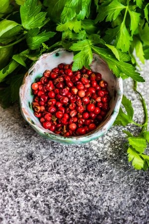 Top view of bowl of peppercorns with parsley