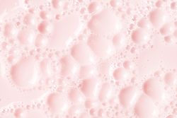 Light pink soap bubbles on liquid surface