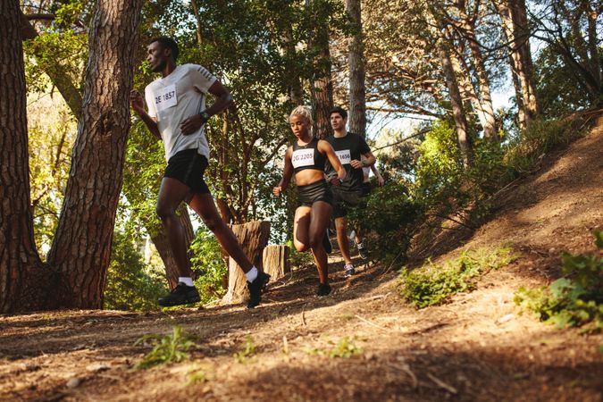 Athletes running down hill on mountain trail