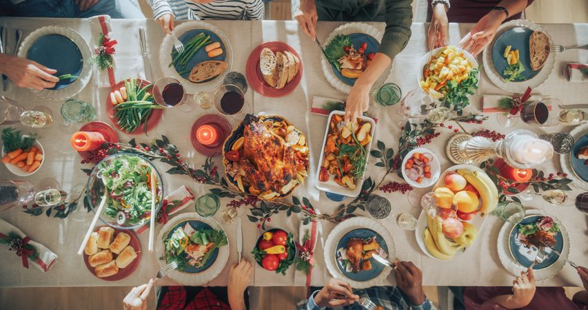 Diverse Group of Relatives and Friends Sitting Together Behind a Dining Table with Tasty Meals and Festive Decorations.