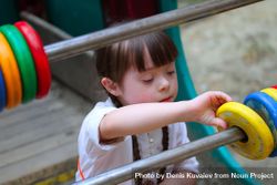 Young girl with serious expression playing with an abacus outside 0PzRe4