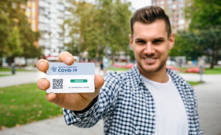 Man showing health passport indicating that he is immune to coronavirus