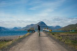 Man walking towards rural bridge