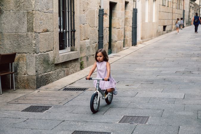 Girl riding on bicycle in narrow street