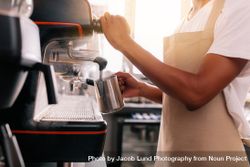 Close up of young man preparing coffee on machine 4mNkdb
