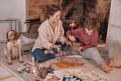 Child enjoying free time at home while painting with mom