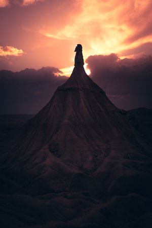 Stone peak in desert against evening sky