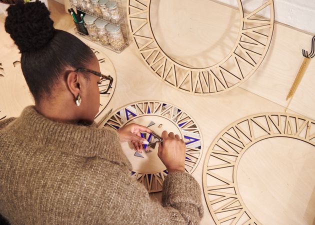 Black female designing cutting wooden panels for a project