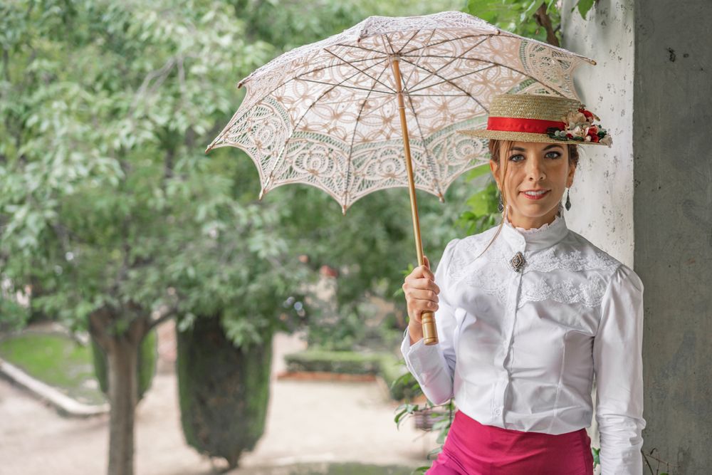 Vintage woman with parasol resting in garden