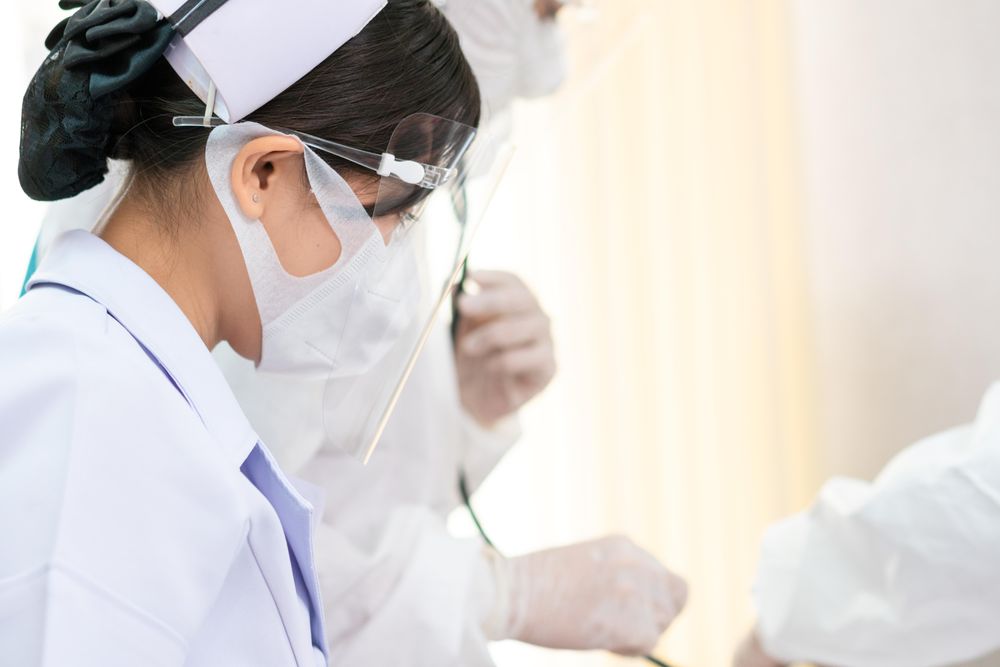 Asian nurse in protective mask and face shield