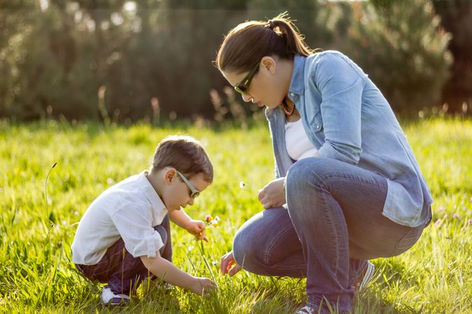 Mother and son picking flowers in a field