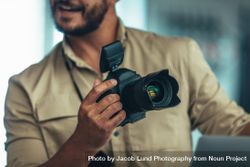Portrait of a photographer holding a DSLR camera 56yrV0