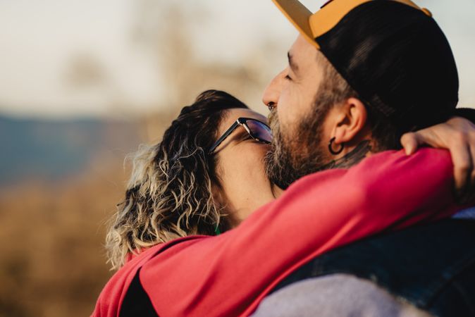 Young lady biting guy in tattoos