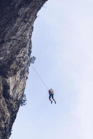 Anonymous climber handing on cliff