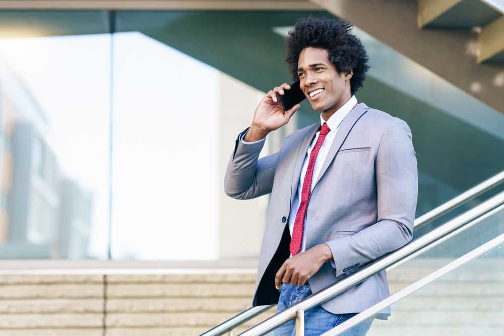 Happy man talking on his phone on staircase
