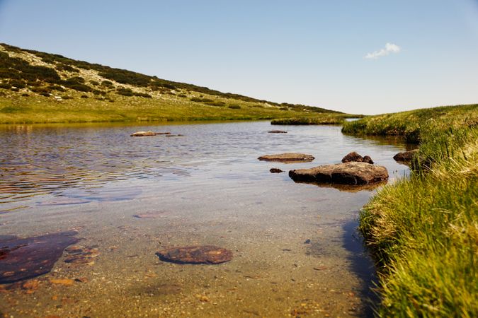 Clear lake at bottom of rocky mountain