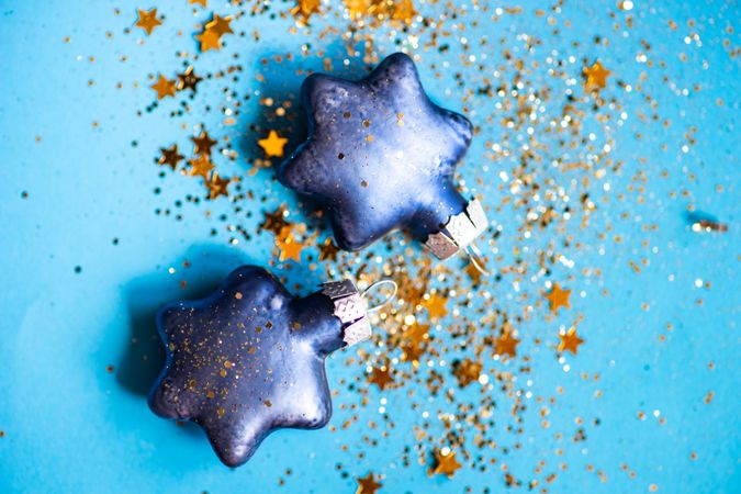 Festive xmas card concept of star glitter on star decorations on blue background