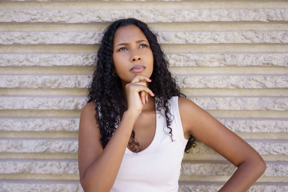 A Contemplative Young Woman Engaged in Deep Thought Set Against a Textured Background