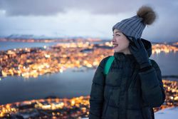 Joyful millennial woman enjoying view of night city