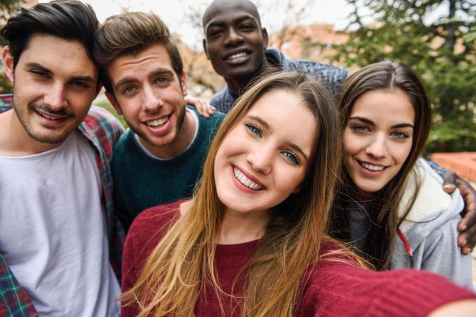 Smiling group of friends looking at camera and posing for picture