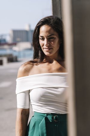 Young pensive woman standing in the street while looking down