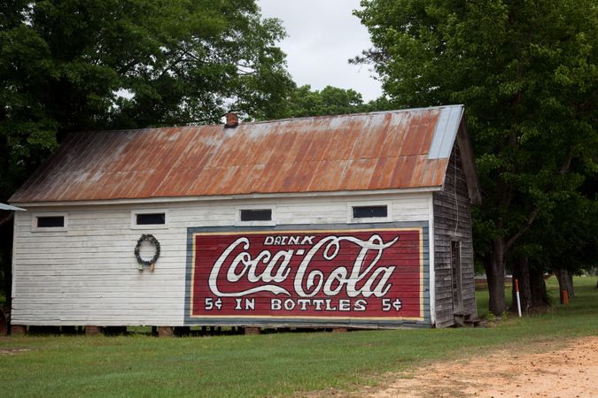 Rustic barn with rusted roof and vintage Coca-Cola sign in rural Alabama