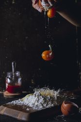 Cook preparing dough and breaking eggs