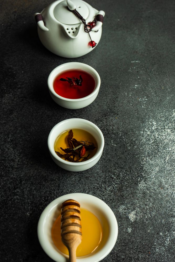 Honey and two cups of teas and tea pot