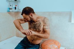 Young shirtless bearded guy with tattoos