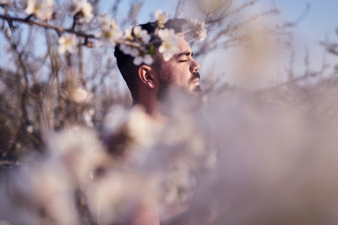 Shirtless man meditating in spring garden