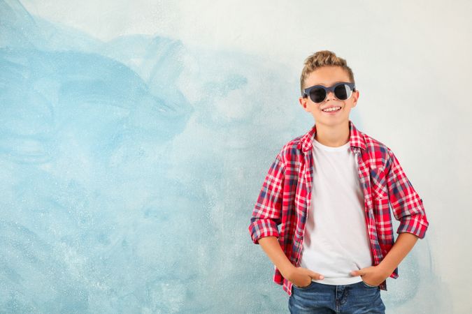 Steep boy with sunglasses against color background, space for text
