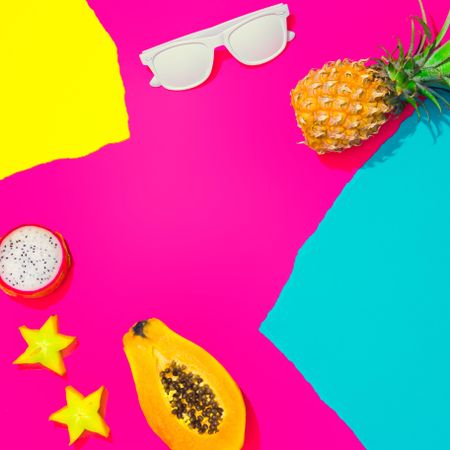 Pineapple, papaya, starfruit and sunglasses on pattern of ripped paper in vivid colors