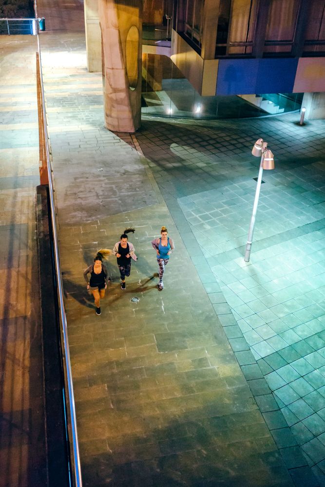 Women friends runners training together in the empty city at night