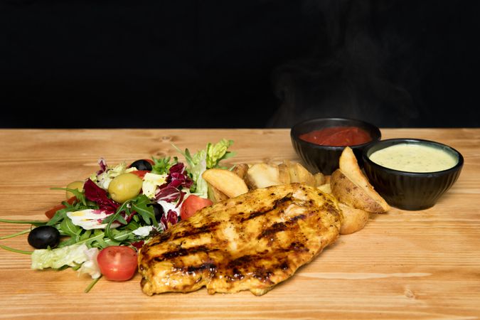 Fried meat and vegetables near ketchup