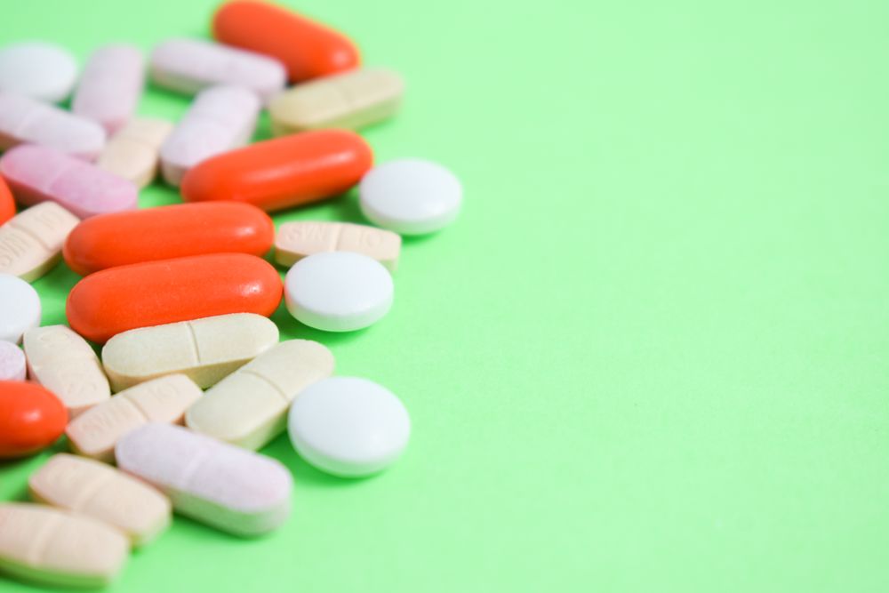 Variety of pills on green table