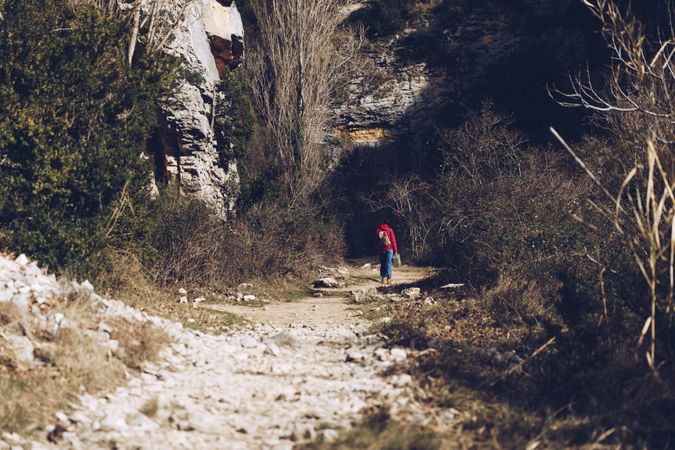 Traveling woman on road in rocky cliffs